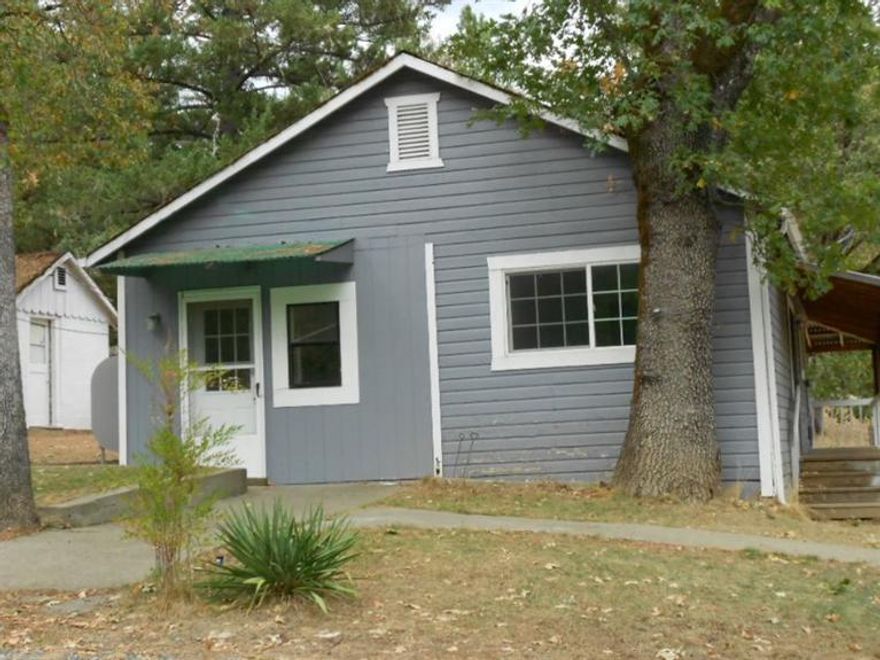This charming little 2 bedroom/1 bath farmhouse on 1.25 acres sits in a peaceful wooded setting. Lovely deck off the kitchen area for BBQ's or sitting outside. An oil heater setup to augment the electric wall heaters. New electrical panel. Underground sprinkler system for lawn and garden areas. A separate building is a cool room for those fresh veggies and your canning. Two other detached buildings, one carpeted would make a great office or craft room and the third building could make a shop or storage building. New well flow available, ask for copy. Owner is willing to carry the loan.