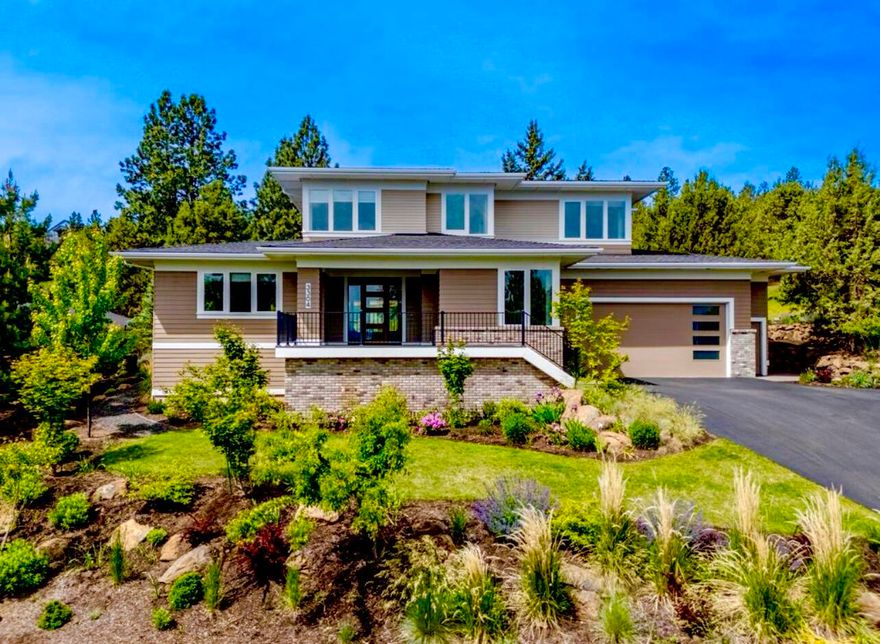 On Bend's NW side in River's Edge Village, this impressive Prairie Style home offers expansive views of the eastern skyline from an elevated homesite.  Built by award winning Structure Development NW, this expansive floor plan offers main level living with an open great room design featuring a fireplace w/ built-in cabinetry, large windows bringing in abundant natural light, spacious & well designed kitchen with quartz countertops, upgraded appliances & large center island. Wide plank wood floors, modern fixtures & lighting, & a gracious primary ensuite bedroom w/curbless shower, double vanities and walk-in closet. Office/den, laundry & mudroom also on main. Plus 3 bedrooms, full bath & bonus room upstairs. Enjoy outdoor living & entertaining with privacy on the covered back patio while viewing double golf course fairways & surrounding wooded, pastoral terrain.  Beautiful garden landscaping with perennial flower beds.  Large garage w/ enclosed hobby room.  Earth Advantage certified & Solar Panels.