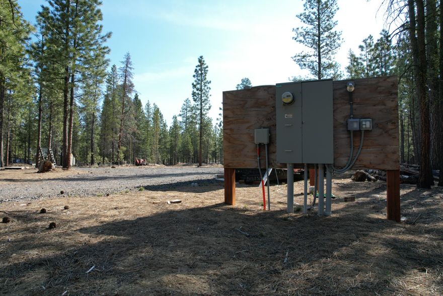 Ready-to-build 1.55  acre homesite with extensive improvements in place. A topographical and geotechnical survey has been completed, and the centrally cleared 120' x 160' proposed building site is prepped and approved by Deschutes County. The lot features a circular driveway, partial grading, and selective thinning for optimal aesthetics and access. Utilities include 400A electric service Mid State Electric Co-Op, a 1'' waterline with two frost-free hydrants (Ponderosa Pines Water Co.), and fiber optic internet (TDS). An RV pad with water, 70A power (50A 220V & 20A GFCI), and internet is also installed. Approved ATT septic system for 4-5 bedrooms by DEQ. A mobile 8' x 32' office/storage trailer with temporary power and HVAC remains on site and is negotiable with the sale. This turnkey lot offers significant time and cost savings for your custom home build in a private, forested setting.