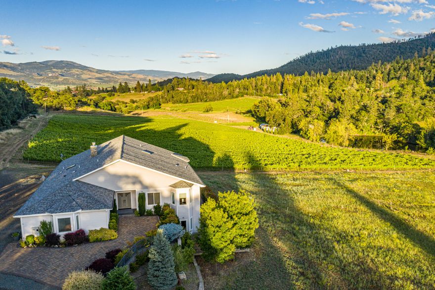 Located in the foothills of SW Medford, this 63-acre property features a custom home, 50 acres of water rights, an incredible setting with great views, and 17 acres of vineyard! The 5,039 sqft modern home has a bright & open floor plan with energy-efficient I.C.F. & S.I.P. construction. The main level includes the living room, family room, spacious kitchen, expansive master suite, deck, office, & more. Downstairs is a bonus room, two guest suites, and ample storage. The property has Class I & Class IV soils, a shop, a greenhouse, two ponds, and creek. The +/- 17 acres of Class I soils are not yet planted and are ready for cultivation to a wide variety of crops. For years, Southern Oregon has been one of the premier destinations on the west coast for individuals and families to move to. Known as a niche agricultural community with a strong small-town culture. The climate is highly sought after with four distinct seasons including mild winters and long growing seasons.