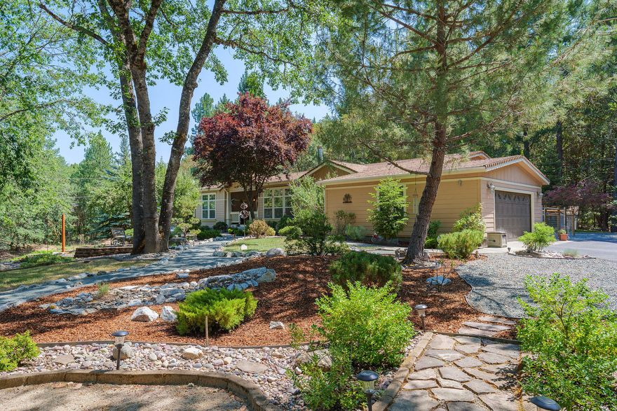 The paved driveway leads you up and around to a beautiful and spacious 2800 sf (mfr) 3 bedroom (split bedroom plan) and 2.5 bath home nestled on 1.08 acres.  This light and bright home is welcoming and comfortable...you enter into the formal living with the master bedroom and bath to your left.  There's a perfect sized formal dining area off the open kitchen with it's own sitting area.  The fireplace serves both the kitchen and family room designed with a perfect spot to sit and play games or do your favorite puzzle!  The kitchen is open to the family room serviced by the open bar area complete with stools.  The built in wall unit will meet all your movie needs...Just off the family room and the 2 bedrooms with bath is the utility room that opens to the garage or to the fenced area out back.  The shop is 30x48 with 3 bays/garage doors.  It has its own electric meter and comes complete w/ the air compressor! The grounds are mature w/ some fruit trees and are mostly low maintenan