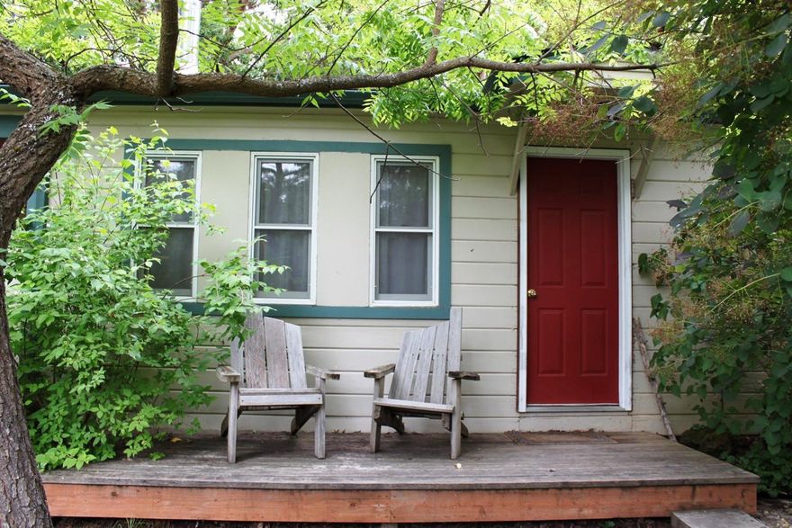 This adorable cottage sits on .42 acre lot in a nice setting with garden area & trees with lots of room to expand. Two bedroom, one bath, 722 sq. ft. Kitchen has glass top range/oven and stainless double sink & nice cabinets. Nice bath with stone flooring, shower and pedestal sink. Wonderful old hardwood floors throughout with stone in the bathroom. Having both the old and new, there are some newer vinyl windows with blinds or curtains. There is an inside laundry with storage area, carport & back deck for entertaining in the summer. You will love this warm and cozy home that offers so much charm.