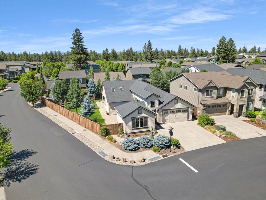 This elegant single-level Pahlisch home in The Bridges sits on one of the community's largest lots, a .20-acre corner that opens to the south, creating a bright, open feeling rarely found in a neighborhood setting. Mature landscaping frames a wrap-around paver design connecting a spacious back patio and a charming side patio, ideal for outdoor living. Inside, the vaulted great room with gas fireplace and rock surround flows into a chef's kitchen with skylights (remote blinds), walk-in pantry, large island, quartz counters, stainless appliances, and a wine bar with sink and fridge. The versatile front bedroom features built-in cabinetry, perfect as a home office or guest room. Three full baths offer comfort and convenience, and the oversized 597 sf garage includes shop space. Resort-style amenities—pools, clubhouse, gym, game room, walking trails, and 15 acres of common area—complete this desirable Bend retreat.