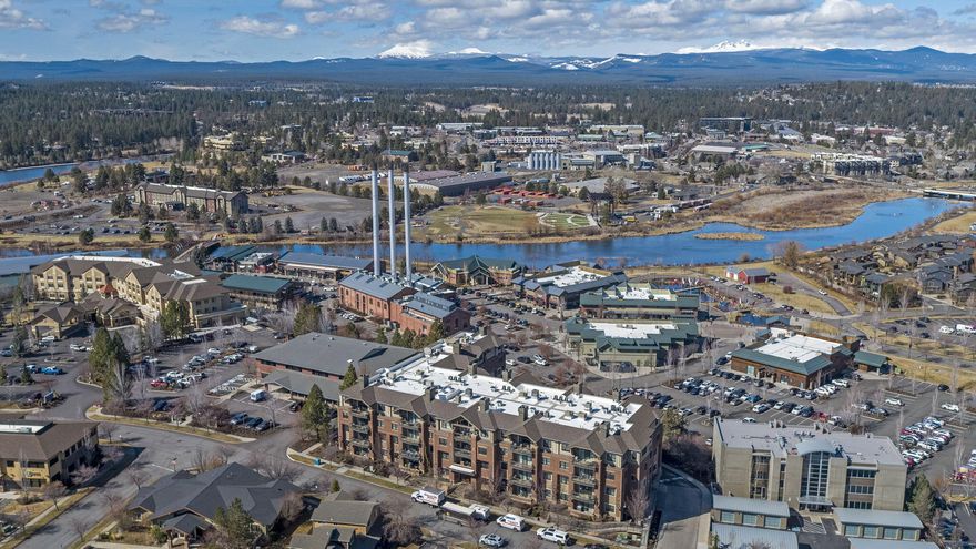 Live in the heart of it all! The Plaza is mere steps away from popular local restaurants, shopping, breweries, river trails & Bend's incredible amphitheater. This spacious condo faces west overlooking Bend's historical smoke stacks, expansive Cascade mountain range & the Deschutes River. Located on the 2nd floor this unit features two primary suites & large flex-space for 3rd bedroom, yoga/meditation or private office. Chef's kitchen hosts timeless granite counters, large working-island, SS appliances & exquisite cabinetry throughout & outdoor patio to watch the sunsets. Tons of storage throughout & this unit offers 2 deeded parking & 1 storage unit. Building amenities include secure access/parking, entertaining room w/fireplace, full communal kitchen, outdoor patio w/gas firepit & BBQ. The Plaza offers secure/heated parking garage & additional storage lockers. HOA includes water/sewer, garbage, snow removal, building/grounds maintenance & insurance.