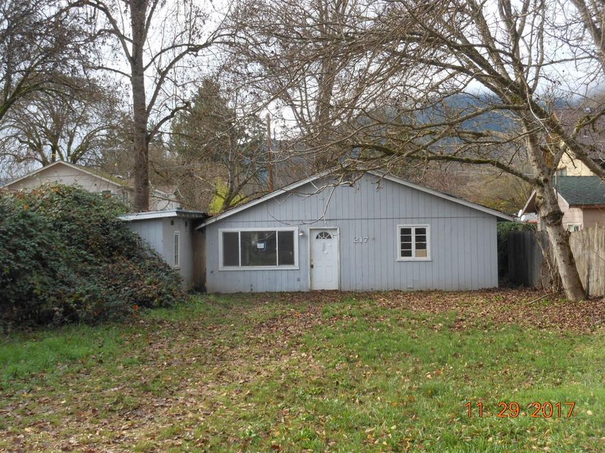 Large R-2 Lot with a 3 bedroom 2 bath home. Home will require major repairs-can not be occupied without repair. Check with the city about adding another unit or starting over with a nice duplex. Close to all services Rogue River has to offer. Property is sold in current as is condition.