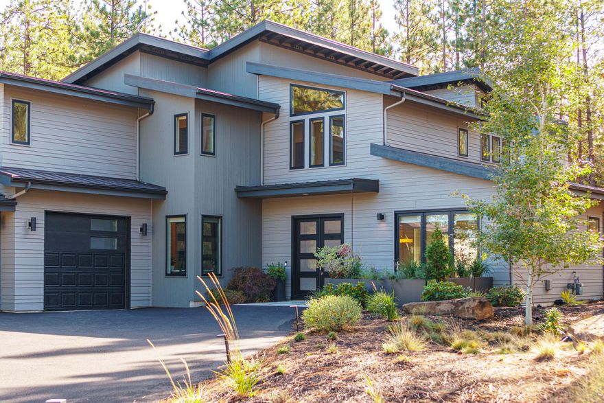 Stunning Contemporary in the highly sought after Tetherow community on Bend's Westside! With exceptional architectural details throughout, this thoughtful 4BR, 3.5BA lives generously. Open concept Great Room, home office, and an opulent Primary Suite with spa-like bath on the main level. Chef's dream kitchen offers functional sophistication w/ quartz counters, expansive island, 6-burner range and XL side by side fridge/freezer. White oak hw floors & rich Koa wood door accents. Second level: Spacious Bonus Room, Jr en suite, 2 add'l BR, and shared BA with sleek, refined finishes. Positioned for privacy & livability on .34 acre sanctuary setting w/ sheltered back patio and yard. Approx.1,100 SF patio w/ plumbed gas heaters to enjoy dining al fresco, entertaining & relaxing in the spa throughout the seasons. Three bay fully finished garage includes one bay converted into a separate at-home gym. Fantastic community amenities to enjoy including pool, gym, walking trails and dining options.