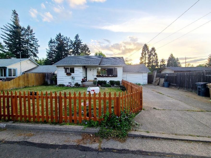 1940's charming home in a quiet neighborhood! Perfect for a first-time home buyer! A large and FULLY fenced front & back yard with a deck perfect for entertaining or watching the sunrise and sunset. LOTS of parking for everyone, an RV, boat or? This home is light and bright! Heat & light protected, semi darkening custom blinds included. An oversized one car attached garage fits 2 cars easily with room to spare. Great location, close to shopping, schools, park and the Rogue river. GP Irrigation and lots of room & sunshine for a large garden and/or pets. Come see today!