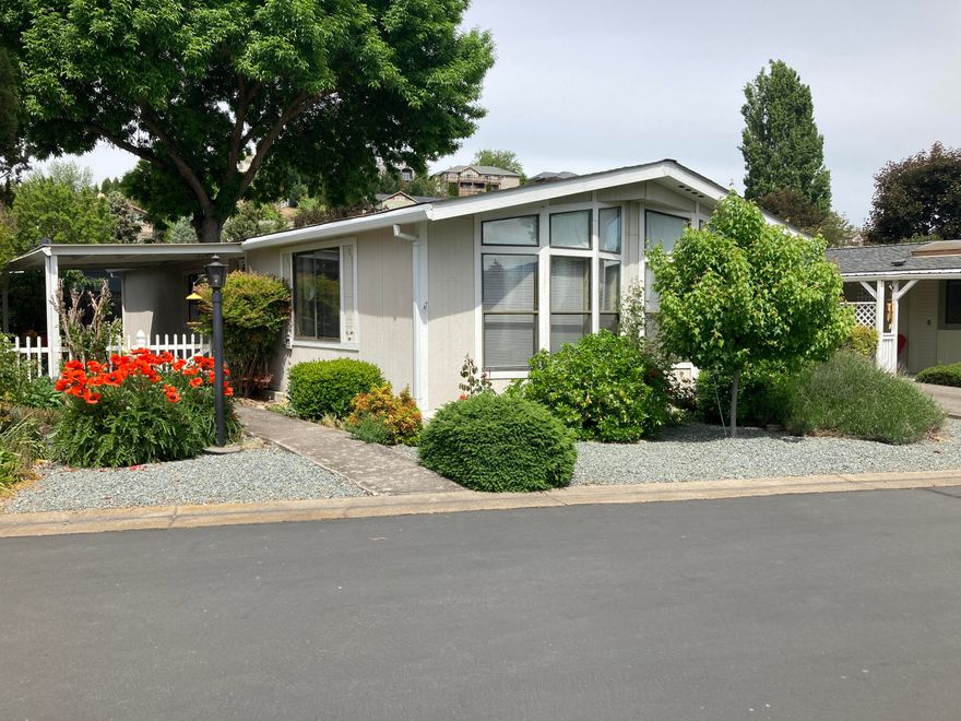 Nicely maintained and landscaped 2 bedroom, 2 bath home in the highly desired 55+ Rogue Valley South Manufactured home park.  Main section of home and bedrooms are all drywall, tape and textured.  Great little breakfast bar, separate dining area with built in hutch and large living room. The laundry area has room for Fridge or Freezer.  All appliances are included. Primary bedroom has en-suite bathroom with deep soaking/garden tub and separate shower enclosure.  Bright and open with lots of natural light, plenty of storage and covered porch-patio area. Yard is fenced and nicely landscaped.  Main shed in carport and second shed in backyard is handy place for all your gardening tools or extra storage. Great location on private lane with fantastic views of pastures and mountains.  Overflow parking nearby.  Boat and RV storage in park, swimming pool, club house and picnic area. Move in Ready.