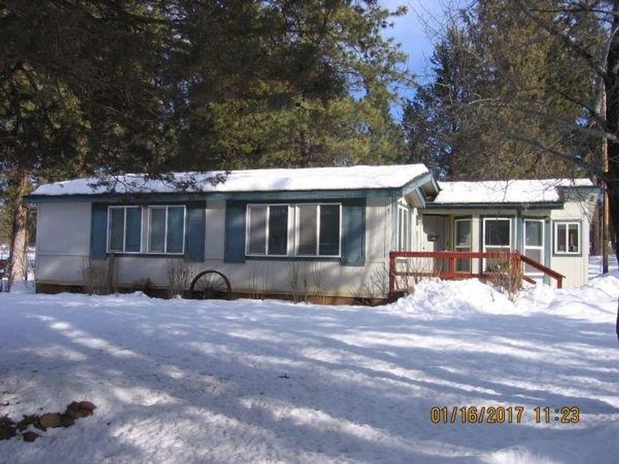 Don't miss out on this beautiful 3 bedroom 2 1/2 bath triple wide manufactured home on 8 cross fenced acres with many extras. Roof is 7 years old. Hardwood floors throughout except the bedrooms, which are all carpeted and kitchen (linoleum). There is a carpeted 13' X 16' bonus room in front of carport for additional entertainment. There is a shop equipped with air hoses, outbuilding, pump houses, outdoor wood storage shed and more. There is also a seasonal creek that runs through the property. Great for horses. Round Lake Rd. is paved to the shared driveway. The 1.2 mile long dirt access road is shared by 8 residents. This home is the 3rd house from the end. This is a must see! Don't let this one pass you by.