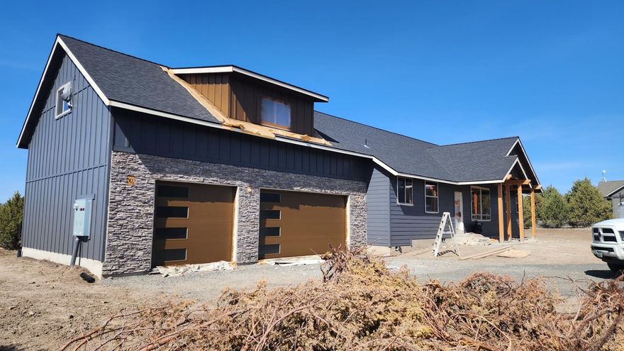 Beautiful custom home on 2.04 acres in the gated community of Mountain Ridge Estates that borders BLM. Currently under construction, this home offers 2496 sf of open floor plan with vaulted ceilings, 3 bed, 2 bath & includes a large bonus room over the 3 car garage. Main living space offers luxury vinyl plank flooring, propane fireplace and abundant natural light throughout. Kitchen features solid alder, custom cabinets, SS appliances with an island with butcher block and granite counter tops w/full height backsplash. Primary suite boasts vaulted ceilings, large walk-in closet w/ shelving. Primary bathroom has vaulted ceilings, tiled floor & fully tiled walk-in shower, enclosed toilet, double vanity w/ quartz countertops & solid alder cabinets. Home is prewired for solar & a prewired automobile charging station. Also includes a 400 amp service for the possibility of a future shop, which can be discussed w/ builder.