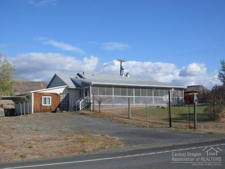 Dayville Home On .5 Of An Acre! Views of the John Day River, Aldrich Mts & John Day Valley, open floor plan, 2 bedroom, 2 bath, large utility room, wood and oil heat, vinyl windows, sun room, family room, covered and screened in front deck, deer fenced front yard, fenced back yard, composition roof, vinyl siding, water rights, carport, fruit trees, storage shed, wood shed, attached shop area or potential for single car garage. $92,000 #861