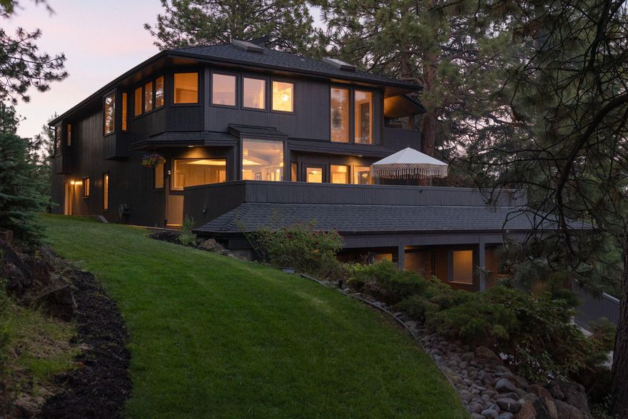 This 1970's West Hills stunner is made for good times. Nestled in the trees you'll enjoy views from nearly every room or one of the many private decks. Listen to the 15' interior waterfall cascading into a serenity pool. Have a nightcap in the bar and entertainment area. Apres ski anyone?

On the first floor you'll find 2 bedrooms with a shared bathroom.  One with a private porch and fireplace. Also a 3 car garage with tons of storage.  Glide up the stairway into the open concept living space with ornate fixtures, mirror-coffered and vaulted ceilings. Gather at the kitchen island, or the deck for a bbq surrounded by golden hour skies. Upstairs you'll enjoy the large secluded bedroom and ensuite.  Great views of Pilot Butte.  Feel pampered in this suite  with an XL hot tub, spa-like shower and vast walk-in closet complete with 3-way mirror for all your angles.  

Host amazing parties on this verdant half acre, an easy drive to Mt Bachelor and just minutes from downtown.