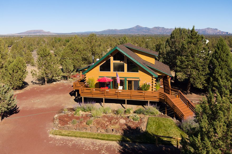 Custom Log Home with a fully wrapped deck on 6.25 acres w/amazing Panoramic Cascade Views, a detached shop, & a 2400sf barn w/ tac room, power, water, 8 stalls, & several fenced/paneled areas. The home features a great room design w/a propane fireplace, a large living area, many access point to the deck, a spacious kitchen, a separate dining area, newer appliances, a main floor primary w/custom natural stone shower, radiant floor heating through slab concrete floors, & a 3-head ductless heat pump system that keeps the home perfectly cool & warm regardless of the weather while keeping electric bills in check. The upstairs has two guest bedrooms, a bath, and a private deck w/views of Smith Rock. The landscaping is amazing and maintained through automated irrigation. The detached shop has room for two cars & a work area & next to the barn you'll find a highly productive fenced garden area on a programable irrigation system. There's even a water feature for ambiance & the wildlife.
