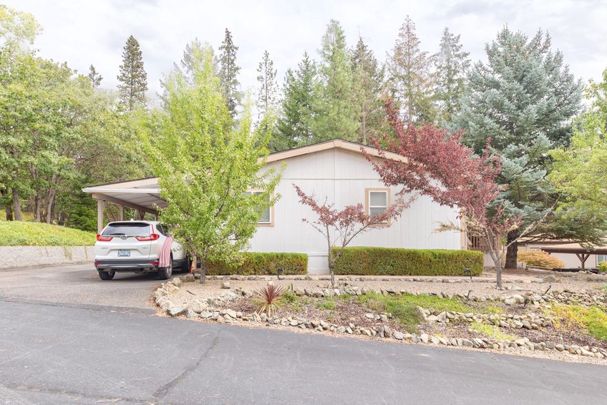 PRICED TO SELL!! Very well-maintained home in the Rogue River Mobile Estates community is ready for you to move into. This 1,350 sf, split floor plan 3b/2b home even has an extra area for your home office, a large kitchen with loads of storage, a buffet bar and all appliances stay with the home. The primary on-suite bedroom is spacious with a nice-sized closet and bathroom with double sinks. Sit out on the enclosed screened patio and enjoy  your morning coffee. Delightful yard has walking paths throughout, raised garden beds,  retaining wall that allows for extra parking, drip system, leaf guard gutter system and not one but two storage sheds for those extra items. New roof in 2019, newer heat pump and new hot water heater. Rogue River Mobile Estates is a 55+ park. Space rent includes water, sewer and garbage. Additional gated RV parking available within the park. Private financing with as little as 5% down is available. This is an amazing deal in a great park!