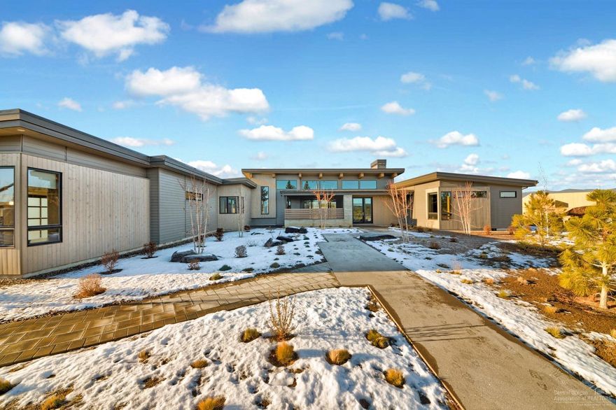 This stunning, single-level contemporary Bend Trend home situated on a premium view lot in coveted Tetherow is a fusion of luxury, style, and functionality. Expansive windows throughout provide abundant natural light and frame the enviable Cascade Mountain views from nearly every room. The floor plan comprises a Master suite with adjacent den, two junior suites, and a media room. Meal prep is a breeze in the chef's kitchen with an oversized island with prep sink, eating bar, two dishwashers, beverage fridge, and Jenn-Air appliances. Seamlessly transition to outdoor entertaining via a wall of sliding glass doors off the voluminous great room, leading to covered patio space with outdoor kitchen. Master suite with spa-like bath features a freestanding tub and tiled walk-in shower. Enjoy epoxy flooring in the 3-car garage, AC and radiant heat with wood/tile flooring throughout, remote blinds, hide-a-hose central vacuum system and pre-wire for solar.