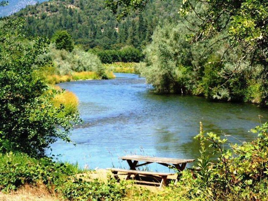 Dream a little....It's a warm summer afternoon and you're sitting on your deck watching the lovely Applegate River roll by, thinking about what to do next, walk down and go fishing, swimming or rafting. Right now it'a a single wide mobile that overlooks the water, but this 5.2 acre irrigated property really needs a custom home to make the most of the views up and down the river. It's easy to justify planting a vineyard to match the one nextdoor, or the beautiful soil is suitable for many crops or animals. It's located in the Applegate Valley near Provolt, allowing great access to Grants Pass or Medford. Price has been reduced by $100,000. It's worth a look.