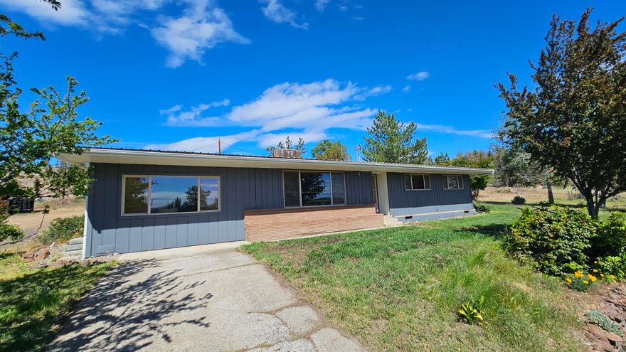 Seller now offering HOME WARRANTY ! 
Come see this Mid Century Modern home in the country overlooking the city of Madras. This rare gem has been tastefully updated with out changing the feel of the mid century modern home that is so desired today ! Original hardwood floors as you enter the home, with stunning original brick surrounding an updated gas insert fireplace.  The open floor plan also offers both a living and an oversized family room and office space area which overlooks the town. The sunrise views of the valley, city, and natural terrain brings the perfect spot for morning coffee with a peaceful setting while sitting on just over one acre.  This home offers 3 bedrooms and 2 bathroom, the primary suite bathroom with a stunning modern update !  Outside there is an RV garage with storage and a perfect work spot area. The desirable location is just above town close to all desired needs in town.