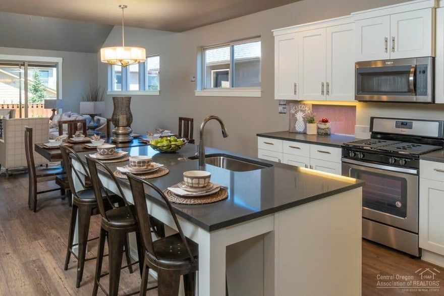 Beautifully designed Wagner floorplan. Single level Pahlisch built Home with open concept kitchen/dining/great room. Vaulted great room with skylights, cozy gas fireplace and expansive sliding door leading out to large covered back patio. Quality finishes include: stylish white wood cabinets, Quartz kitchen & bathroom counters, large kitchen island, stainless steel appliances, luxury vinyl plank flooring throughout main living/kitchen/dining/bathrooms, double wall construction for added insulation, HardiePlank lap siding, masonry, gutters and completely fenced . Middle bedroom includes private bathroom suite and could be used as second master bedroom. Beautifully maintained neighborhood off of SW Canal with easy access to Bend or Redmond. Photos of similar home, specs vary. Model open Fri-Sun, 12-4.