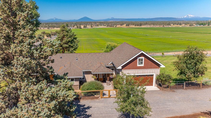 Framed by the Cascade Mountains this property offers 30.5 acres of irrigated land, sweeping views, and a refined ranch lifestyle. Thoughtfully oriented to capture mountain vistas from nearly every room, this property is located between the Deschutes River and Smith Rock. Updated features bring this vibrant hobby farm to life whether indoors or out. The amenity rich property offers flexible land use, vegetable garden, fruits trees and tranquility from living with the earth. Whether enjoying the fireplace, a cooked meal in the chef's kitchen or a nightcap in the hot tub drinking in the sunset this home does not disappoint. A spacious shop provides a place for the machinery and a shop area for the tool collector. With leased pasture potential, water rights, and proximity to Redmond/Terrebonne, this is where self-sufficiency meets serenity—under big skies and timeless peaks.