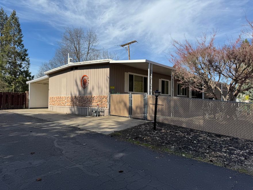 MOTIVATED SELLER.  Back on the market through NO fault of the home. Incredible Value in the wonderful 55+ park; Western Carriage Estates. The double wide home has a fully fenced & gated front yard, large rear deck for entertaining and double length, covered carport for plenty of parking. Pretty kitchen includes formal dining area and breakfast nook. Full size laundry room. Light and bright with accessible features making this a convenient home for entertaining and family gatherings. Plenty of yard space for garden or pets. Park has swimming pool, clubhouse with fireplace, kitchen, library and billiards, game/card tables, shuffle board courts and RV storage. Don't miss seeing this gem today.