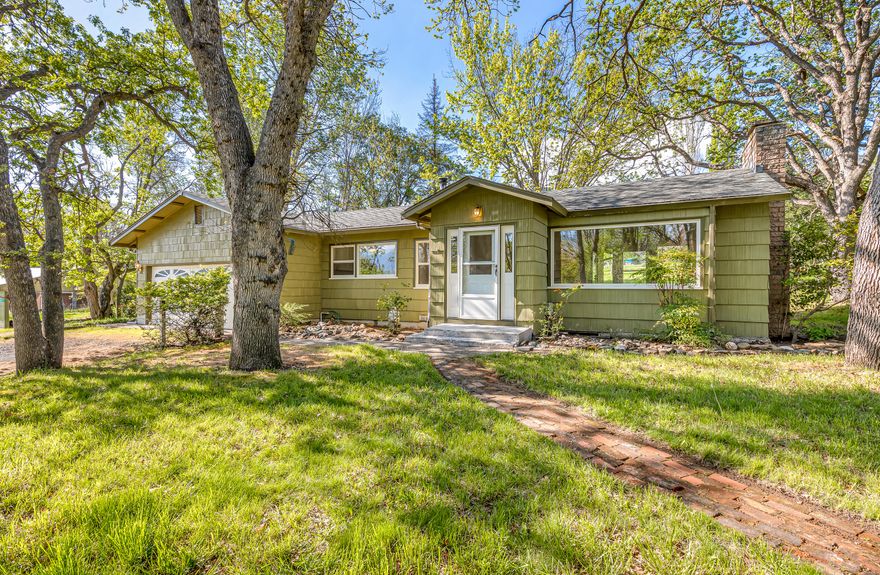 Charming country home on serene acreage with mature trees, pasture, and irrigation rights — centrally located within seven minutes of downtown Ashland or Talent! Home features upgraded double-paned windows with vinyl frames, fresh interior paint, living room with laminate plank flooring, curved archways, built-in shelving and desk, certified wood-burning stove, deck and patio access, fireplace with brick hearth, kitchen with tiled floor, large sink overlooking front yard, solid wood cabinetry, four-burner propane range, two bedrooms with closets, full bathroom with double vanity and oversized shower, and two-car garage with washer, refrigerator, and utility sink. Property is within the Urban Reserve (i.e., Future Growth Area) for City of Talent per 2017 Comprehensive Plan — inquire with land use consultant regarding development potential. Well production of 15 GPM per 1981 well log. On-site septic maintained by Rogue Valley Sewer Services. Inquire with agents for details!