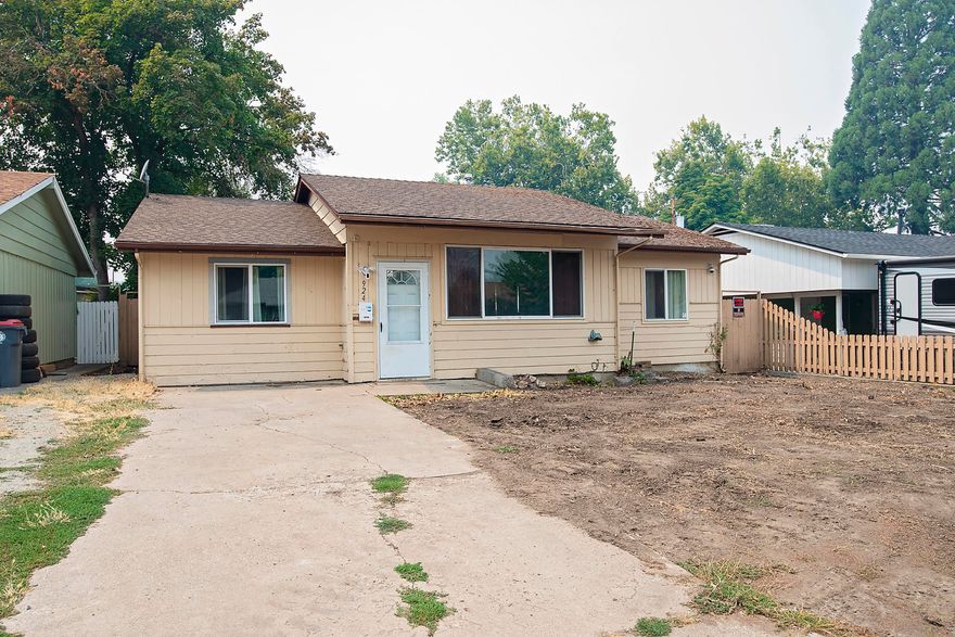 Buyers & investors! This home sits in an established SW Medford neighborhood close to schools, shopping, & emergency services. Several updates have been completed in the last 2 years! You will enter cute living room w/waterproof, laminate wood plank flooring & new SMART thermostat & ceiling fan. Split floor plan w/newer carpet in all bedrooms & upgraded bathroom w/new flooring, vanity w/granite counters, light fixture, & extra deep tub/shower combo. The kitchen has been completely updated w/new cabinets, flooring, SS appliances, & granite counters. Towards the back of the home is an extra room w/newer slider to back yard that could be used as dining, craft, or extra bedroom? Very large utility room for storage, pantry, and laundry. Primary bedroom has small vanity area w/mirror & granite counter. Large vinyl windows throughout provide abundant light! Home stays cool with the newly installed Lennox HVAC system (2 years)! Bring your imagination to the yard with alley access in back!