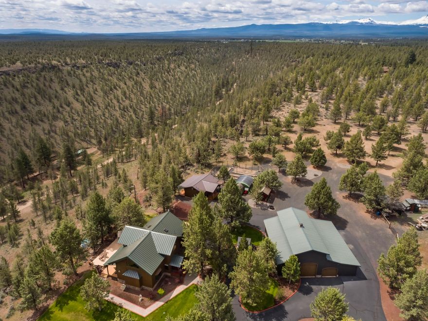 One-of-a-kind reclaimed timber framed home in Sisters! Perched on the canyon wall on over 20 acres, this unparalleled setting offers both privacy and tremendous views. Using 100-year-old reclaimed timbers, beams, and flooring, this home features only the finest craftsmanship. Main home includes an entertainer's kitchen with commercial gas range open to the great room with a floor to ceiling stone fireplace. Additionally on the main level, you'll find two primary suites with ensuite bath. Upstairs, includes an additional primary bedroom with ensuite as well as a loft/flex space overlooking the great room. Plenty of room for family and guests with an additional 600 square foot cottage with full bathroom as well as a 2,600 square foot garage/shop. Animal lovers will appreciate the corral equipped and ready for your four-legged friends and gardeners will love the greenhouse and fenced outdoor garden with raised beds and drip system! Located several minutes from downtown Sisters!