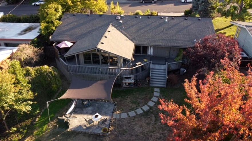 OPEN HOUSE 10:30-12:30, Saturday Feb. 19th! Come tour a dynamic, 1604 sq. ft. home on .27 acres in East Medford near Rogue Regional Medical Center. The impressive solar heating system is owned outright, and makes the electric bills a joy! Two bedrooms + a BONUS ROOM to use as your home office/hobby space or convert to a third bedroom! Host gatherings in the great room w/adjacent living-dining, beautiful hardwood floors, and natural light from the large picture windows on three sides. Start & end your days in the cozy family room w/vaulted ceiling, Jotul stove, and open views to the backyard. Kitchen features granite counters, stainless steel appliances w/gas range, and pantry. Luxurious heated floors in both bathrooms, beautifully tiled showers, master soaking tub, and complementing fixtures & vanities. Easy access from four locations to the wrap around back deck. Hot tub included! Deep backyard w/tasteful assortment of trees + perennial landscape w/stone paths to front entry.