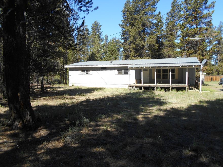 This property is in Great Location!!  Home backs to BLM lands go horse riding  or ride  your ATV  right out your back door. Property has a outbuilding. Nicely treed property!  Close to outdoor Amenities and lakes..  This home is a good location with great water.  This area is exempt from the newer septic system's.  Property is being sold AS-IS, home is in need of some TLC.  This home won't last long in this area.