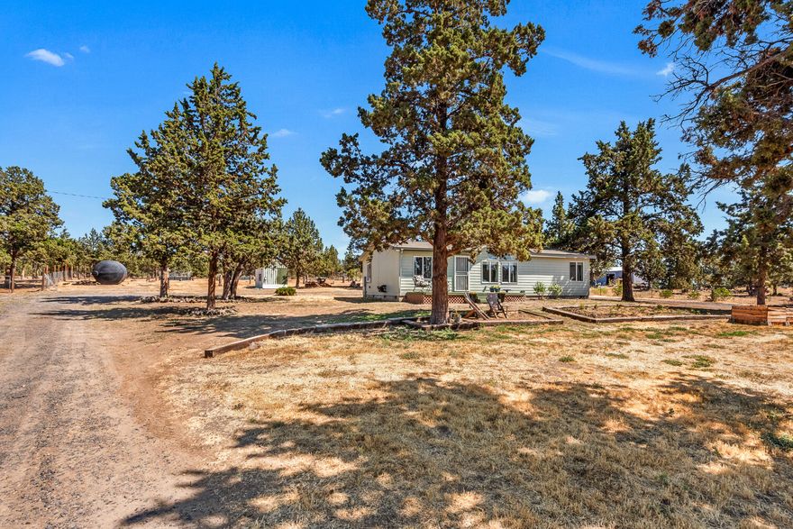Move-in-ready single level 3 bedroom, 2 bathroom house, perfectly situated on a 1.81 acre lot. Step inside and discover an inviting floor plan with vaulted ceilings and laminate wood floors throughout. The kitchen is the heart of the home which seamlessly opens to the living and dining room. The primary bedroom suite is situated separate from the 2 auxiliary bedrooms, creating a true retreat. Outside you will find ample space to garden with raised beds already in place. The detached garage/shop is perfect for storage, hobbies, or animals with a stall opening to a fenced pasture. A circular driveway creates an easy flow for entering and exiting. Prineville is a beautiful place to call home! Nearby attractions include a petting zoo, dirt bike park, Prineville Reservoir, and many hiking trails and campgrounds.