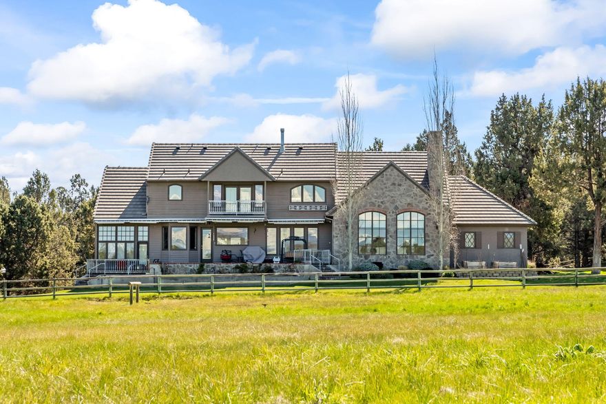 This stunning french country estate spans 5 full irrigated acres in the highly sought-after Winston Ranch area of Tumalo. The property offers dramatic views of the Cascade mountains, visible from nearly every window of the house. the home boast high-end finishes, including slab granite countertops, hardwood floors, large windows and a spectacular basalt rock fireplace. The completely remodelled kitchen is a must-see with high-end appliances, a double island, wine refrigerator and more. The primary suite is located upstairs, with guest bedrooms on the main floor and a 4th bedroom / flex room with adjoining ensuite over the garage. The private and unique setting includes a 3-stall barn, dry lt for horses, a shop with garage and RV/boat carport, underground irrigation, and a round pen adjacent to the lush, fenced pasture. This turn-key property is located just minutes from bend, offers a perfect blend of luxury and rural charm in Winston Ranch.
