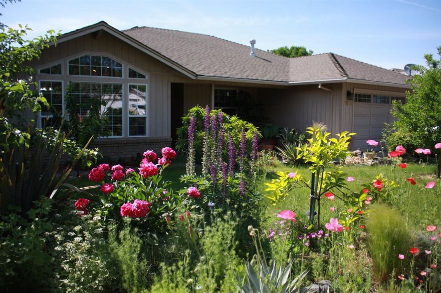 Gardener's paradise! Incredible yard and house with an exceptional rural feel in a quiet southwest Medford neighborhood! This large 3 bedroom 2 bath house on almost a quarter acre has been maintained by master gardeners and offers a huge variety of plants and vegetation - plums, cherries, apples, persimmons, lime, strawberries, succulents, bamboo and many more. Home features a spacious bright kitchen with lots of cupboards, large wood windows, stainless appliances, sun-tubes, vaulted ceilings, plenty of storage, hookups for the RV, and an excellent covered patio with hot tub. Back yard features a gorgeous grape adorned pergola, a view of the mountains, raised beds with watering system, play area for kids, and even a chicken coop. This home has to be toured to be appreciated!