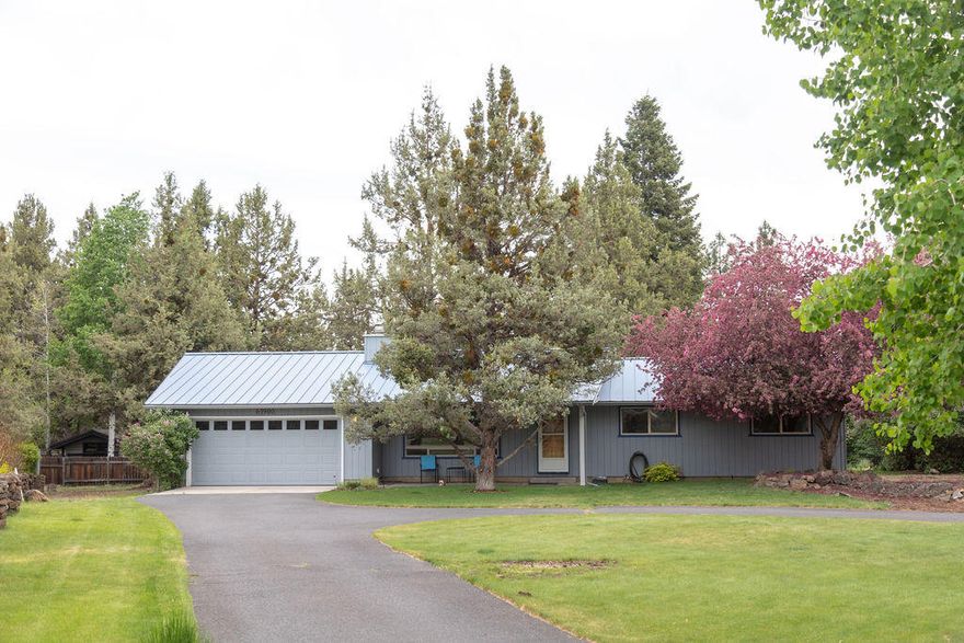 Best of both worlds! Just outside the City limits so you're close to shopping & schools but minutes from everything country: Riley Ranch, Tumalo State Park and a local hangout, The Bite! This home is centered on a .51 acre lot that is surrounded by established mature landscaping, it's like living on our very own park.  In fact, every window has a view of gorgeous lawn, the garden or a blooming tree. This quintessential rambler blends characteristics of its era like a floor to ceiling lava rock encased wood burning fireplace with new features like a recently remodeled kitchen & updated bathrooms. The kitchen was recently completely redone with granite counters, custom cabinets, upgraded stainless  steel KitchenAid appliances & a full wet bar that can double as a prep sink and workspace. The backyard is a private paradise with a covered patio looking out over gardens, lush grass and mature lilac bushes. There is even RV parking that will accommodate up to a 45' RV & has a 50 amp hook-up.