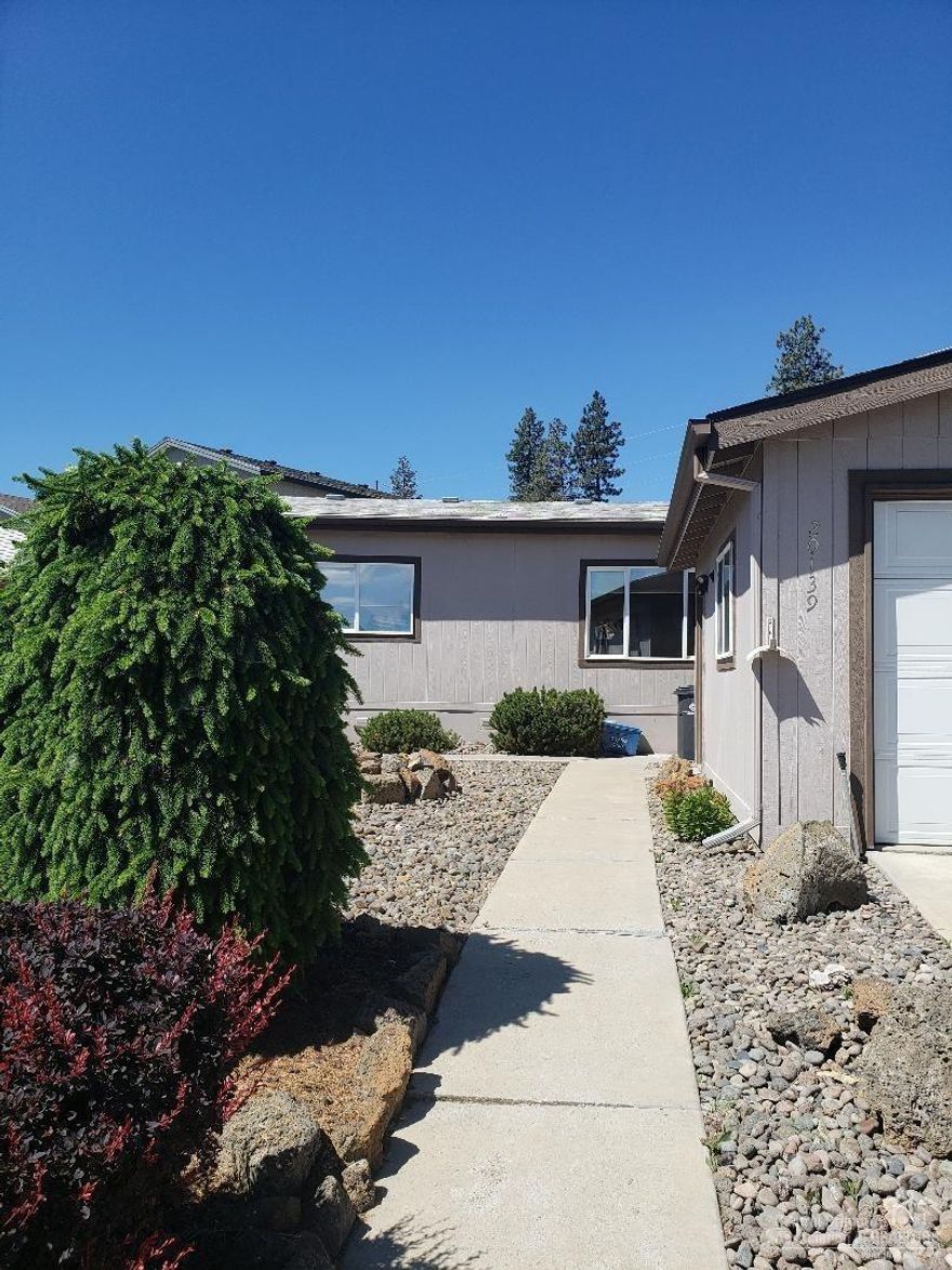 Squeaky Clean with upgrades 3 bedroom 2 bath near shopping and restaurants in very nice manufactured home park near shopping and restaurants. Newer countertops, bathroom fixtures, laminate floors, blinds, ceiling fans, air conditioner, pellet stove, pantry and more.Situated in a quiet cul de sac on a low maintenance lot.Dbl garage is large enough for most pickups. Nice sized covered back deck with plenty of room to B.B.Q's.Home features an open concept. Private park and club house.