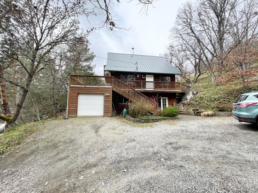 Private entrance to a 1810 sq.ft. 4 bedroom 2.5 bath home on .23 acre lot. Terrific views of the city and nature. The main floor living room has a wall of glass to the deck and views. Main/middle floor contains formal dining room, efficient kitchen and indoor utility room includes washer and dryer, and half bath. Upstairs has two bedrooms, a full bathroom and small deck off one bedroom for views. Lower level has 2 bedrooms, full bath and recreation room. Abundant storage throughout the home. Single car garage is extra long for a workspace or another car. Terraced yard, garden areas and large trees. Lots of privacy with city services. Feels like a Chateau style treehouse.