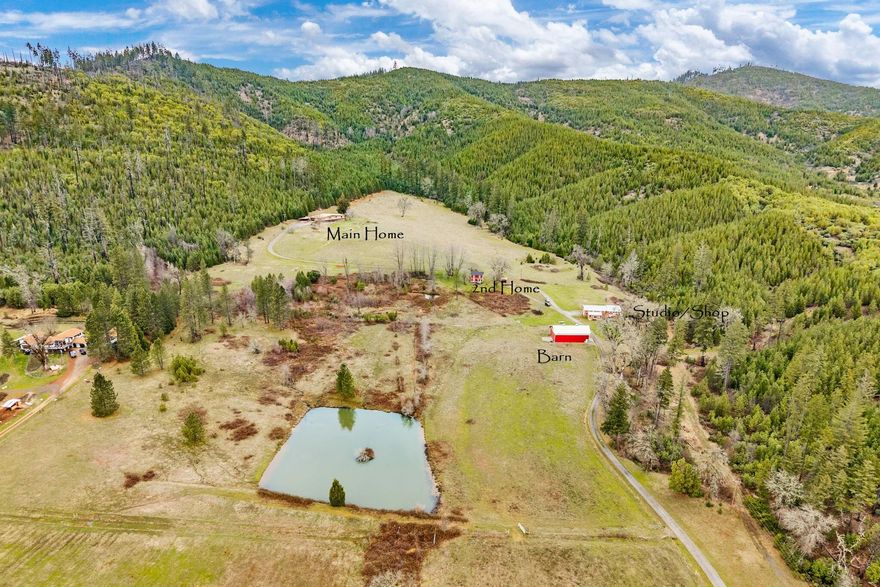 Southern Oregon Dream Ranch on just over 76 Acres located just 1 hour from the Medford International Airport and 1.5 Hours to the Coast.  Stunning Mt views. 2 homes, 1 Studio, 2 Barns, Shop, carport, pond, pasture, springs & over 14 irrigated acres.  Main home has had recent updates, 4 bdrms + office/den, 3.5 baths, 3976 SQ FT.  Slate tile entry, new windows, trim, 2 newer HVAC, and flooring. Open beam wood ceilings, lg kitchen w/butcher Block Island, gas propane cooking and new s/s appliances. Primary suite w/French doors to deck with views, woodstove, updated bath w/ heated floors, quartz counters, soaking time & tile shower. 2nd Home is the original 1800's Farm House w/2 bdrms, 1 bath, 1526 SQ FT w/new windows, roof, foundation, front porch & more! Living rm w/French door to deck overlooking the pond. Shop w/water heater, full and half bath and w/d hook ups.  Studio and Office off the shop.  Backs to BLM on 1 side property is fenced w/a paved road and gated entry.