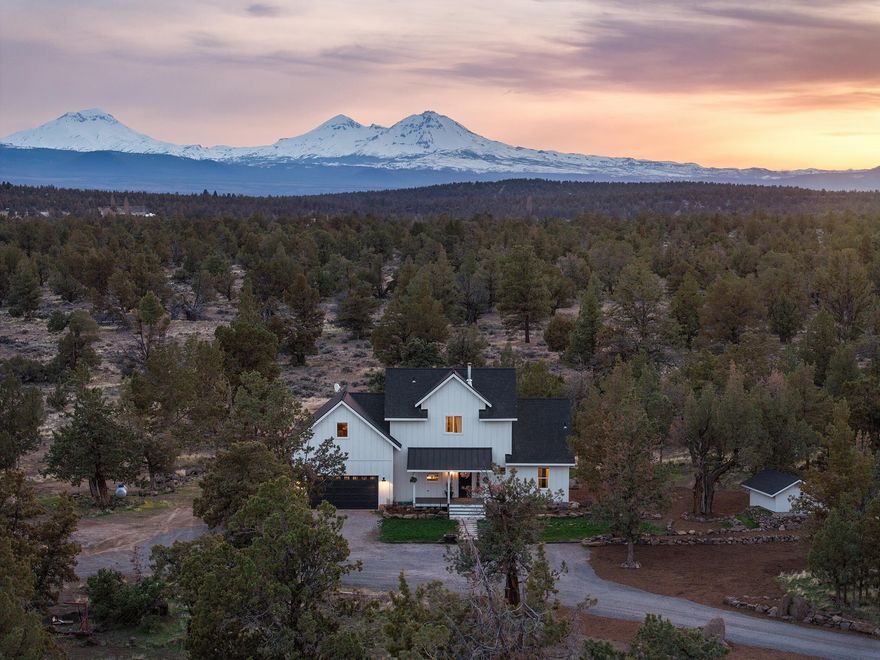 Completed in 2020, this bespoke modern farmhouse sits on 5 acres in desirable Tumalo w/ breathtaking Cascade Mountain views & direct access to thousands of acres of public land. A peaceful retreat, it features a 2,160 sq ft 3-bay shop, framed ADU, addl workshop, & chicken coop. Inside, curated design elements elevate every space—quartz countertops, bamboo flooring, farmhouse sink, touchless faucet, gas range, & reclaimed beams from a historic Sisters building. A cozy propane stove adds warmth & character. The main-level primary suite offers vaulted ceilings, spa-like ensuite with tiled shower, dual vanity, and walk-in closet. Upstairs includes a bright vaulted loft, bonus room (potential to add a 4th bedroom), 2 bedrooms, and a bath with deep soaking tub. Just 5 mins to The Bite & 15 minutes from Costco & Cascade Village Shopping Center—Trader Joe's, Target, Lowe's, Home Depot, & more—this property blends rural serenity with urban convenience. Assumable VA loan & seller carry option.