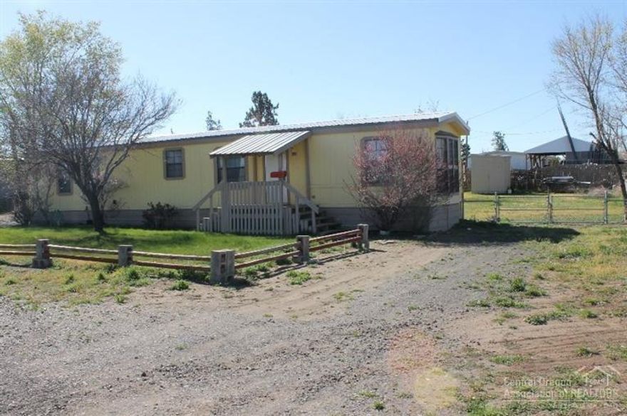 Affordable housing. This home offers a great room floor plan with a bed & bath at opposite ends of the home. Newer vinyl flooring throughout. There is a wheel chair ramp to the back door, large covered parking, room for RV parking plus room for a shop. Lots of potential here. Situated on a large .34 acre lot, 2 storage buildings & fenced back yard too!