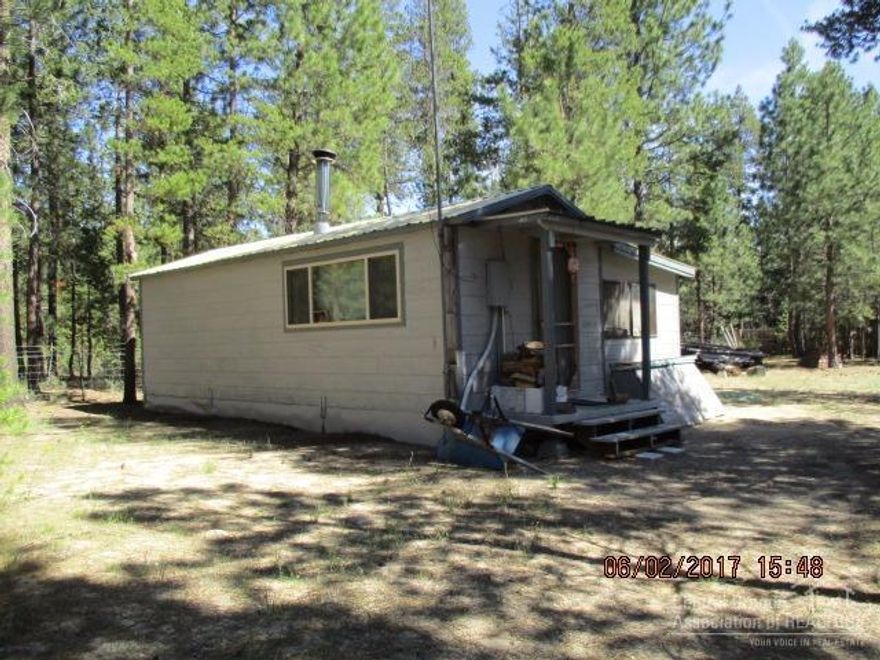 Seller's ready to let this cute little cabin go so you can make this your get-a-way or permanent home site. Furnished and ready for you to get down to living. Lots of knotty Pine for that real cabin feel. Sit by the fire & enjoy those cool evenings. Park your vehicles & toys in the 25x40' shop/garage that has a metal roof, dbl 9'doors & a cement floor. Shop has room to work on your projects too. Property has many mature trees, fenced & gated too. Ready for your additional ideas.