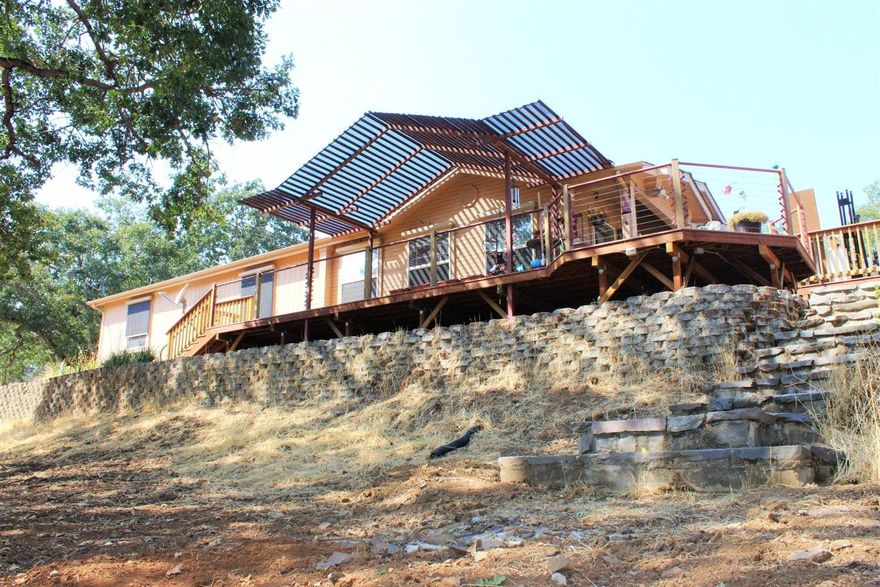 Enjoy the vast views from the wrap around front porch. This home is situated on 7.69 acres and has endless possibilities. The owner has enjoyed the wildlife that this area has to offer, birds, wild turkeys, deer etcThe 1995 double wide has vaulted ceilings, ceiling fans, newer AC/heating unit, newer roof and a remote control that operates the thermostat and blinds. The spacious family room has a beautiful view of the front of the property. The master bedroom has a large closet and its own master bath including a garden soaking tub. The gem of the property is the 40 x 60 shop with two roll up doors, electricity and extra room for storage. The owner operated a machine shop in the out building. The well produces 2.5 GPM with a 1000 GL holding tank and a reverse osmosis system. Great family home for horses or a child's 4H project.