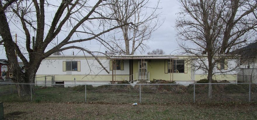 Large .51 acre level lot with an older, single wide manufactured home. Great 960 sf workshop. 2 large sheds, 288sf & 144sf. May be possibility of building additional dwellings. Buyers to do their own due diligence regarding all aspects of the property.