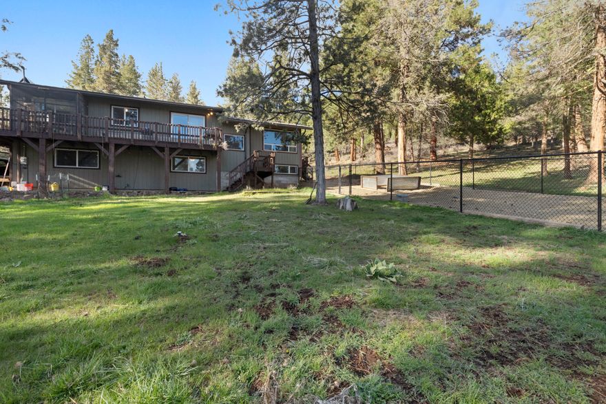 Beautiful property surrounded with various Pine and Juniper trees backs up to BLM!! Home has 3 bedrooms and 2 baths upstairs, and 4th non-conforming bedroom/den, bonus room, bathroom and laundry downstairs; all bathrooms include bidet seats. Attached two car garage downstairs. Kitchen features an island, built-in wine rack, and sliding glass doors leading to the wrap around deck. Professionally built fenced in yard area off of the living room deck is great for entertaining and pets. Property includes a dog kennel, small barn with loft and animal stall. Seller will credit Buyer up to $10,000 towards Buyer Closing Costs at closing.