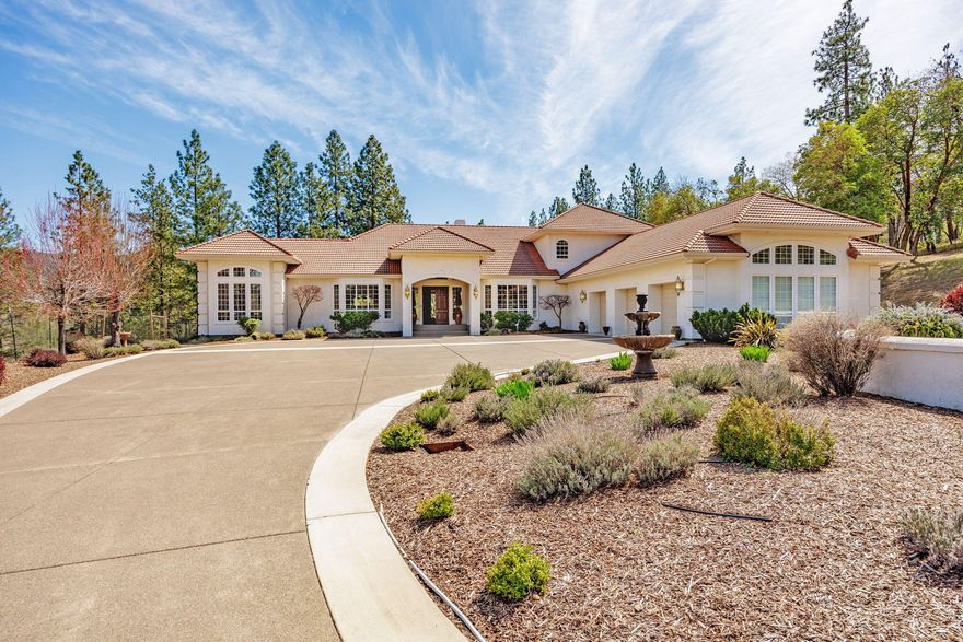 Stunning Mediterranean estate in the sought-after Sun Ridge Estates—a luxurious, close-in rural community surrounded by equally elegant estate properties. Custom-built 5,776 sq ft home features true main-level living. 4 beds, 5.5 baths on 4.84 acres, perched high overlooking park-like grounds and mountain views. Open and inviting floorplan with incredible natural light. Spacious and well-appointed kitchen makes indoor entertaining a breeze. It has ample storage, great counterspace and convenient access to the outdoor patio and pool. Formal and informal living as well as dining. Primary suites on each level. Main level suite features a spa-like bathroom, jetted tub, tile shower & an adjacent sitting room for quiet mornings away from the hustle and bustle. There is second suite upstairs with a private patio. Custom in-ground pool, tiled cabana with full bathroom. Gated drive, beautiful entry and plenty of parking both inside the 1400 + SF garage/shop and on the property.