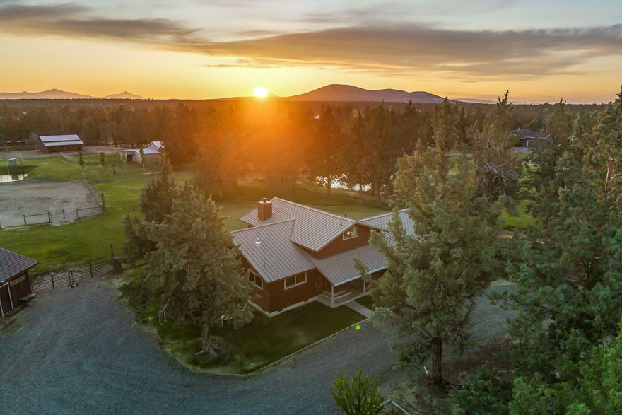 Discover this unique opportunity with tremendous potential for hobby farming, space to spread out, and a convenient location minutes from the airport, Sisters & Bend. This DREAMY Central Oregon property has acreage and potential! Situated on over 5 acres with (3 acres) irrigation, this special place is perfect for those seeking space for livestock, gardens, or just enjoying the tranquility of rural living in SW Redmond. Featuring a primary suite, guest bedroom, & a finished bonus room/enclosed loft for extra storage or living space, the home offers comfortable, spacious rooms, and the warmth of open beam and vaulted ceilings in a well-designed floor plan. Heat pump and woodstove for added pleasant livability.  Take in the mountain views from the large main room windows, or relax on the sunny deck overlooking the large, sparkling pond. Property is fenced, has 3 pastures, and features corrals & animal shelters, in addition to an on-site, triple bay shop. READY for YOU!