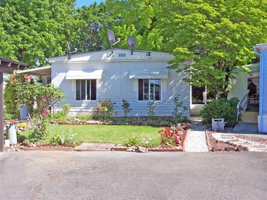 Affordable Comfort in Double-Wide Beauty! This home is located in Rogue Lea Estates for residents aged 55 & older. The features include 2 bedrooms, 1.5 baths, large living room, formal dining room, convenient kitchen with laundry room at one end & an extra room added-on at the front door. All windows have been replaced with double-paned windows & this home is equipped with a large Bryant Heat Pump, Whirlpool bath tub, beautiful newer vanities in the bathrooms, tile counters & has newer range/oven & refrigerator in the kitchen. Everything has been well maintained with some upgrades. A very nice, breezy sitting area has been established in the backyard for enjoying the flowers & country atmosphere especially in the warmer months. The park has an active clubhouse, a lake to fish in without a license and nice neighbors. The location is convenient with shopping, gas, & even the local hospital nearby. Come take a tour; you might be surprised!