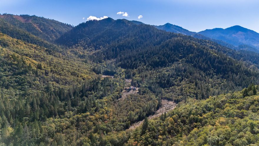 59.26 Acres Backing to nearly 450 Acres of BLM with OWNER FINANCING OPTION!
Incredible opportunity to own nearly 60 acres of prime Southern Oregon land just minutes from the Rogue River and downtown Grants Pass. This private retreat offers unmatched seclusion, wildlife, and recreational access.
The property features a 1,255 sq ft home and detached garage, both need TLC, making this the perfect project for a builder or dream-home seeker. There's also a 720 sq ft shop with potential living quarters upstairs.
Enjoy Little Savage Creek, mountain views, and five cleared areas ideal for pasture, gardening, or building. Abundant wildlife, natural beauty, and huge potential! Owner financing with sufficient down.