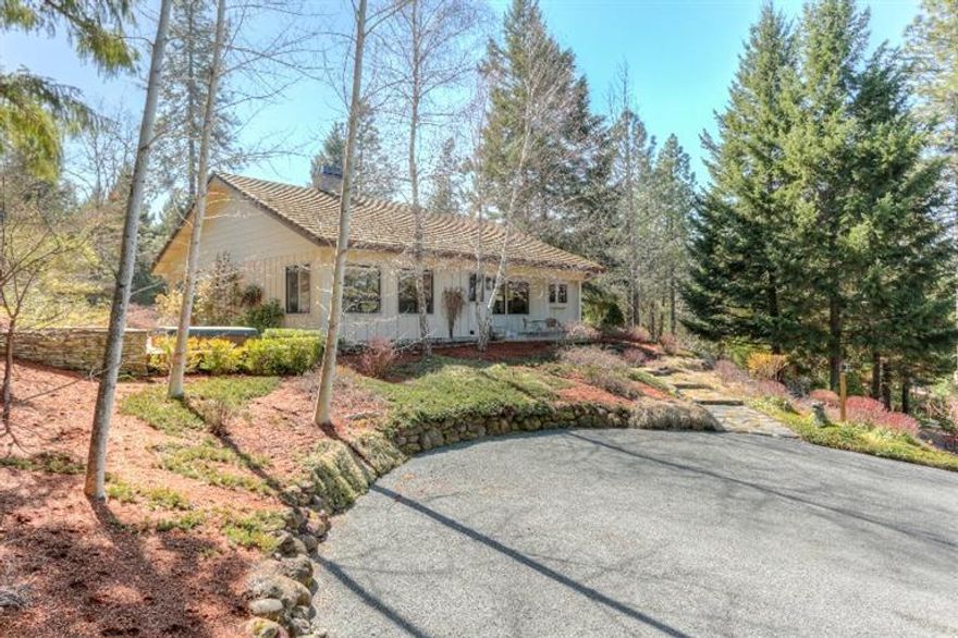 Custom Home in a Private Setting with Lovely Views, situated on 5 acres, this 2216 sq ft 3 bed, 2 bath home features great room with hardwood floors, rock fireplace wi built-in entertainment center, vaulted wood ceilings, wine bar, windows overlooking the pasture & views and double French doors leading to the covered deck and back yard. The spacious kitchen boasts plenty of counter space with solid surface counter tops, oak cabinets, breakfast bar & eating nook. The adjacent laundry room has a folding counter and cabinets galore. The master suite features window seats to take in the view, walk in closet, dual sinks and a hot tub just outside. The additional two bedrooms are located up the stairs and are nice size rooms. The exterior features include beautiful landscape with ledge-stone & rock walls, tile roof, oversized, attached 2 car garage with sink, newer 3 stall barn part of which has a concrete floor and c/be used as shop space, chip sealed driveway & gated entry. A must tour!