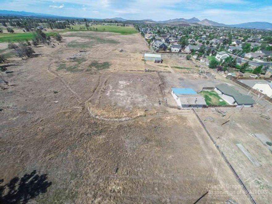 Development Opportunity with Immense Potential - 21acres w/prime location & Cascade Mountain Views. Adjoins developed residential area, near shopping/schools, easy access to Hwy 97, & utilities not far. Property is 1 tax lot - 1.45ac currently in the city limits & 19.55ac in Urban Holding Zone. 2007 Northwest Area Plan shows R3, R4, & R5 zoning, allowing mixed density. Home w/barn & garage included. Housing Inventory is low, demand is high - investment could pay off tremendously. Ask for 2 eng. concepts.