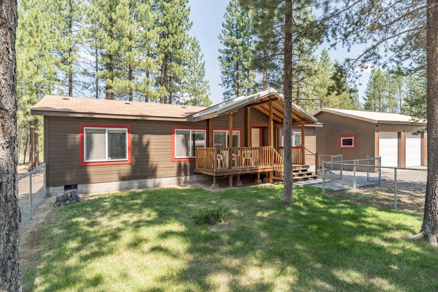 Welcome to your new place of respite, tucked in the Ponderosas! This cute, well maintained and move-in-ready manufactured home in Ponderosa Pines is truly something special. Situated on 1.18 acres, this property is in an excellent location right at the beginning of the subdivision, backs to BLM land, and just a quick drive to paved roads. On the property is a 2-bay shop with an additional storage room, and the cutest bunk-house that was previously used as a home office. The home features a brand new primary bathroom remodel that includes a beautifully tiled shower, new water proof laminate flooring, and new faucet - exterior paint on all structures is also fairly new! Well-built deck/porch space is at both the front and back entrances, small fenced area in the front yard has grass for kids or furry friends to play safely, and there is a gravel circular driveway for easy entry and exit from the property. You won't want to miss out on the opportunity to make this gem your own!