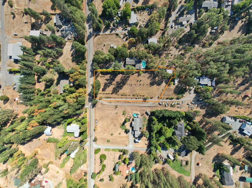 Nice, gently sloping, residential lot.   The site for the original manufacture home remains at the south end of the property.  The garage/workshop building is approximately 440 sq ft and needs some TLC.  The property is fenced and has a vineyard area and fruit trees with irrigation water lines.   The view from the home site is amazing and with a little work and vision, this could be a beautiful location for your home.  SELLER WILL CONSIDER OWNER CARRY.  The property a driveway with a flag lot at 315 Ponderosa Lane (all equipment/vehicles are located on the property at the neighbor's property at 315 Ponderosa).  Do not go on the property without your agent.